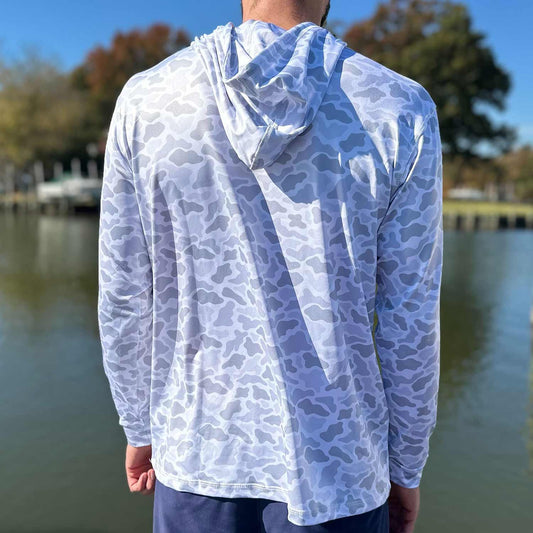 Rear view of man standing in a marina wearing the Six Knots Coastal Camo Performance Hoodie in the ‘Fogg’ colorway — performance fishing hoodie with light and dark gray camouflage pattern, designed for breathability, moisture-wicking, and sun protection; ideal for boating, fishing, and all-weather coastal adventures.