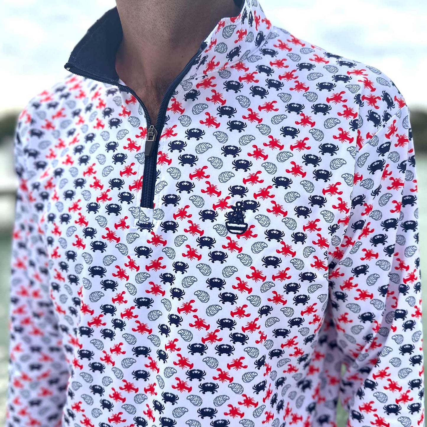 Close-up detail of the Six Knots East Coaster Performance Quarter Zip — lightweight, moisture-wicking pullover with a red, white, and blue repeating seafood print featuring lobsters, crabs, and oysters; ideal for fishing, boating, beach days, and all-weather coastal lifestyle wear