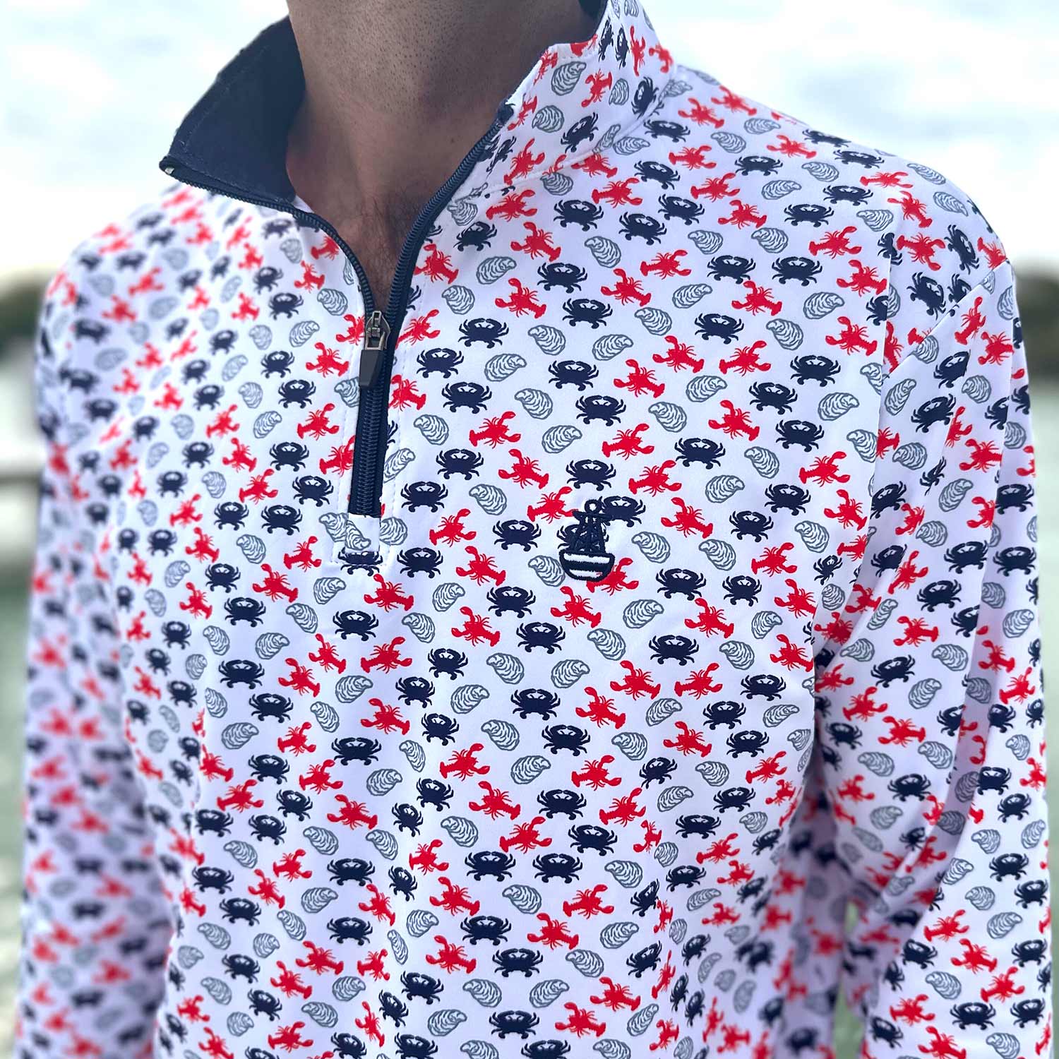 Close-up detail of the Six Knots East Coaster Performance Quarter Zip — lightweight, moisture-wicking pullover with a red, white, and blue repeating seafood print featuring lobsters, crabs, and oysters; ideal for fishing, boating, beach days, and all-weather coastal lifestyle wear