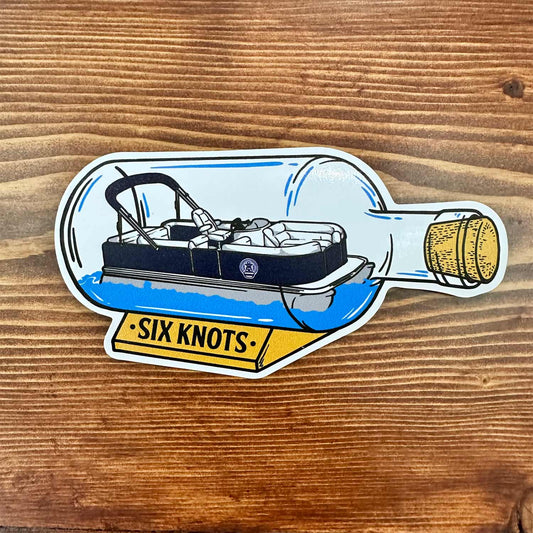 Overhead view of Six Knots "Pontoon in a Bottle" vinyl sticker showing a pontoon boat inside a clear corked glass bottle — weatherproof, fade-resistant decal perfect for coolers, tumblers, tackle boxes, and boating gear