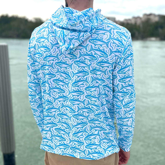 Rear view of man standing on a Florida dock wearing the Six Knots Tuna Time Performance Hoodie — lightweight, moisture-wicking fishing hoodie featuring a bold blue and green tuna pattern with wavy line details; perfect for saltwater fishing, offshore boating, and sunny coastal adventures