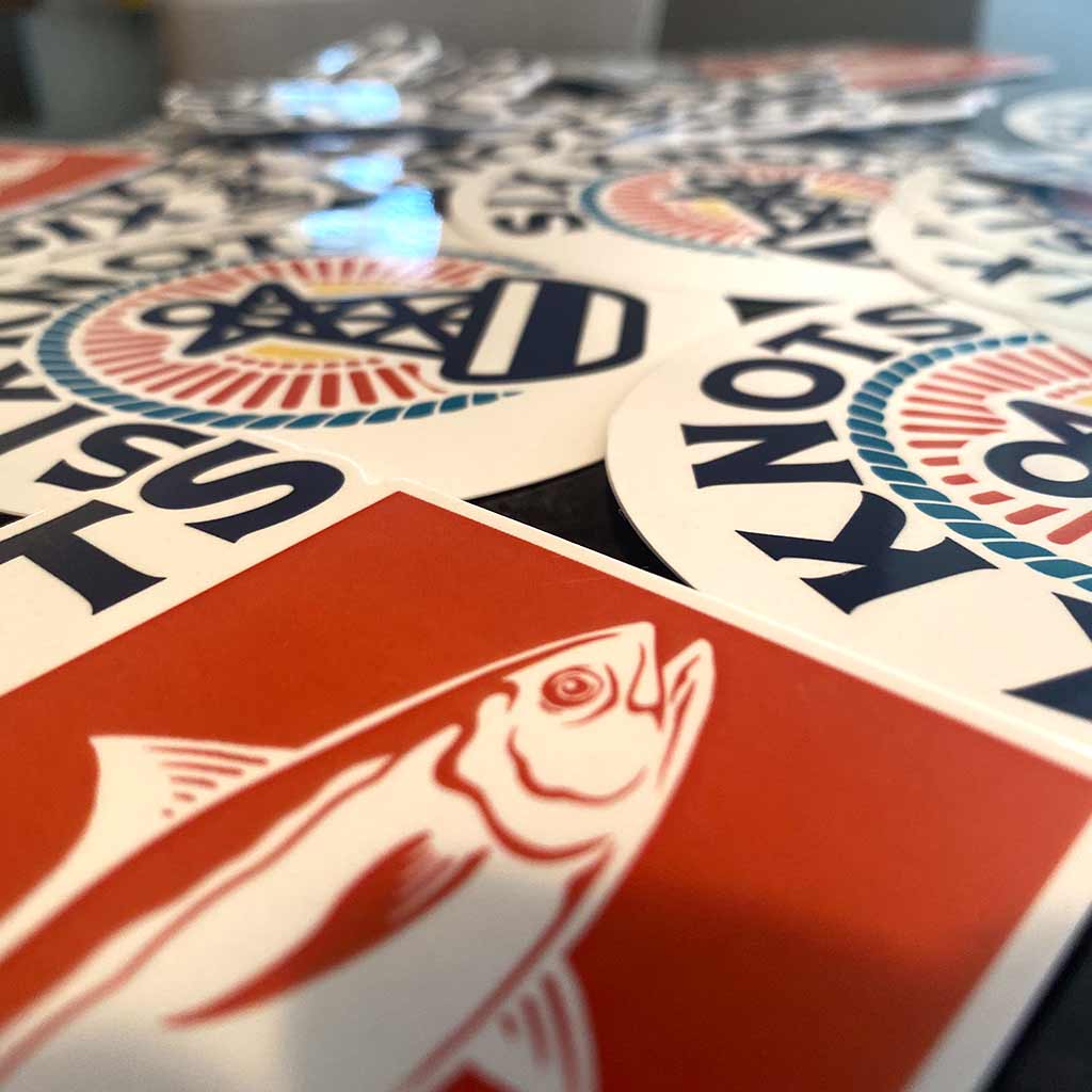 Six Knots stickers laid out on a table