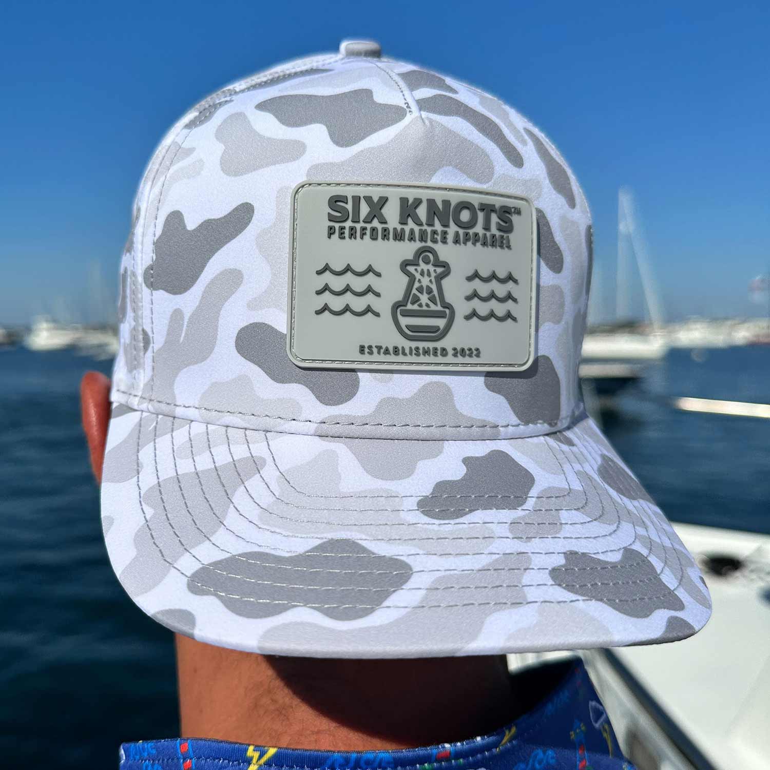 Six Knots hats in tan and white on a table