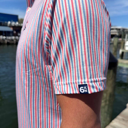 Close-up of Six Knots All American Performance Polo Shirt sleeve showcasing the 6KN logo tag and patriotic red, white, and blue seersucker stripes — lightweight, breathable men's polo perfect for boating, fishing, and golf